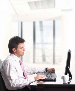 computer worker hunched over computer worker